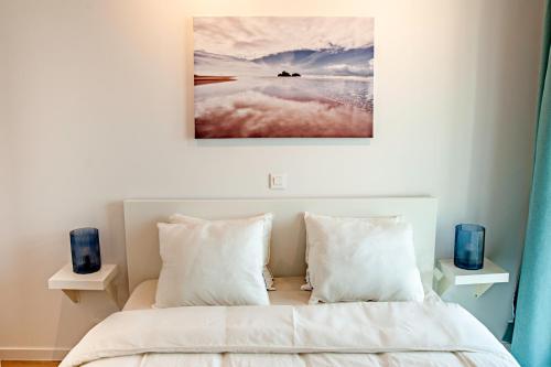 Un dormitorio con una cama con sábanas y almohadas blancas. en The Wonder Shore, en Amberes