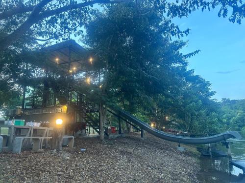 a playground with a slide in front of a tree at ชลลดา ริเวอร์ โฮมสเตย์ แก่งกระจาน in Ban Wang Malako