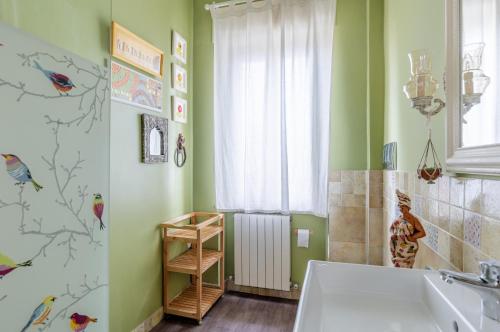 a bathroom with green walls and a tub and a window at Bell’occhio Colorful Apartment with parking in Perugia