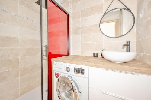 La salle de bains est pourvue d'un lave-linge et d'un miroir. dans l'établissement Superbe Appartement - Exposition Plein Sud, à Hyères