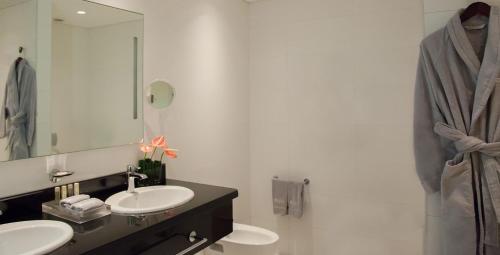 a bathroom with two sinks and a mirror at Eko Hotel Signature in Lagos