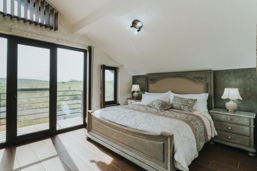 a bedroom with a large bed and a large window at Diplomat Villa in Baile Felix