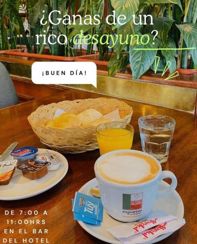 una taza de café y un tazón de pan en una mesa en HOTEL CASTELAR CORDOBA, en Córdoba