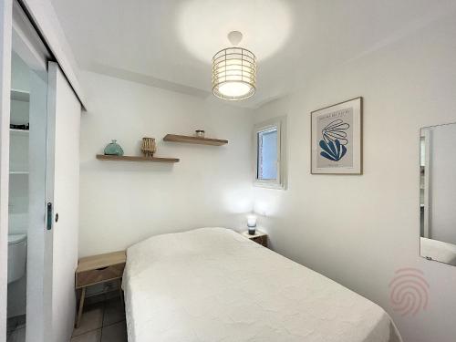 - une petite chambre avec un lit et une lumière dans l'établissement Charmant studio avec terrasse Sud, proche thermes et centre - Lamalou-les-Bains - FR-1-451-190, à Lamalou-les-Bains