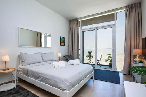 a bedroom with a large bed and a large window at Cozy Studio 29th Floor, Bloom Towers Marina View in Dubai