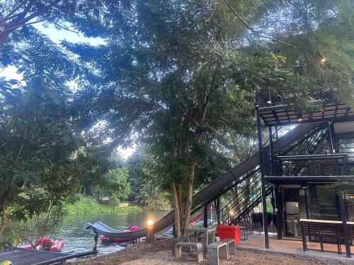 a house next to a river with a boat in it at ชลลดา ริเวอร์ โฮมสเตย์ แก่งกระจาน in Ban Wang Malako