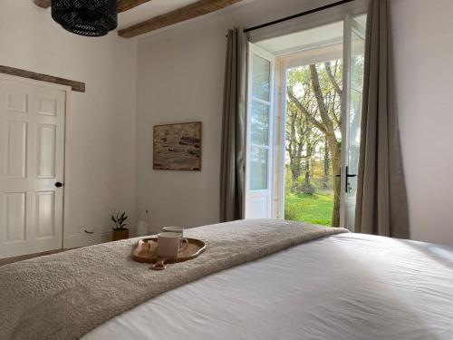 a bedroom with a bed with a tray with a candle on it at Domaine la Boulinière - La Biche in Journet