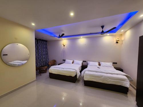 a hotel room with two beds and a mirror at Coffee valley resort (CVR) in Yercaud