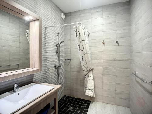 une salle de bain avec un lavabo et une douche dans l'établissement Bel F2 climatisé, terrasse, parking, à 50m des Thermes de Lamalou-les-Bains, animaux acceptés - FR-1-451-193, à Lamalou-les-Bains