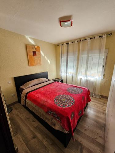 1 dormitorio con 1 cama con manta roja en Habitación en Madrid Capital piso compartido en Madrid