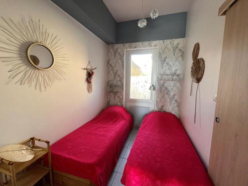 - 2 lits rouges dans une chambre avec fenêtre dans l'établissement Appartement T2 aux Sables-d'Olonne, 4 couchages, proche mer - FR-1-197-575, à Les Sables-dʼOlonne
