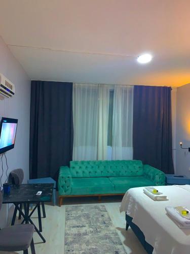 ein Wohnzimmer mit einem grünen Sofa und einem TV in der Unterkunft GMZ SUİT in Istanbul
