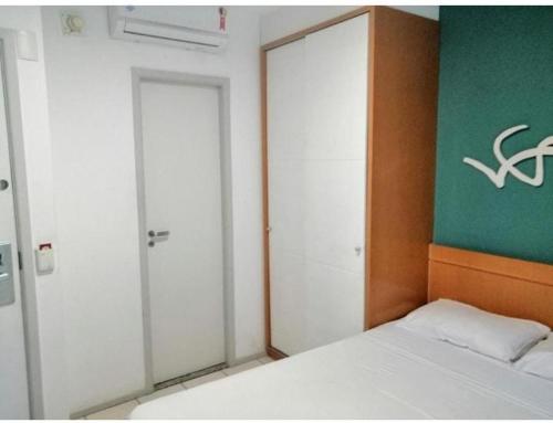 a bedroom with a bed and a green and white wall at Praia do Canto Apart Hotel - Apto 102B in Vitória