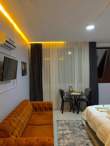 ein Wohnzimmer mit einem Sofa und einem Tisch mit Stühlen in der Unterkunft GMZ SUİT in Istanbul