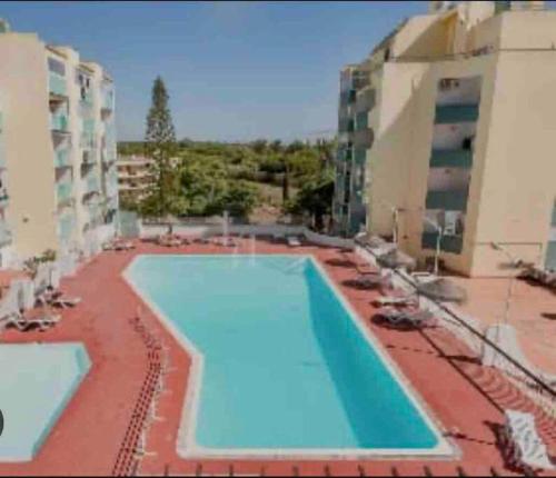 uma grande piscina em frente a um edifício em Spacious 1 bed in Vilamoura, Fast Wifi & Pool em Quarteira