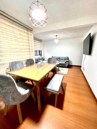 ein Esszimmer mit einem Holztisch und Stühlen in der Unterkunft “Hermoso y cómodo apartamento cerca al aeropuerto! in Bogotá