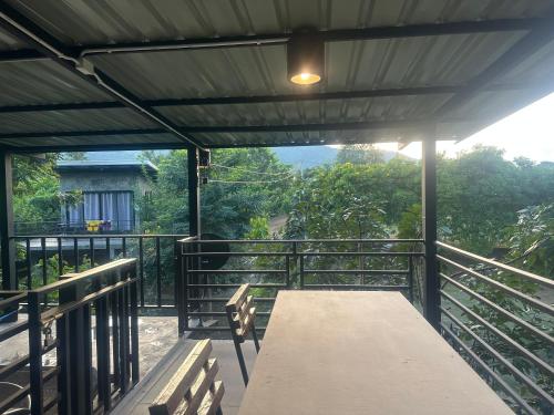 a picnic table on a balcony with a view at ชลลดา ริเวอร์ โฮมสเตย์ แก่งกระจาน in Ban Wang Malako