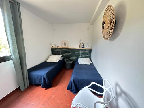 une chambre avec deux lits et une chaise dedans dans l'établissement Charmant T2 climatisé dans résidence sécurisée, proche plage - FR-1-309-394, à Collioure