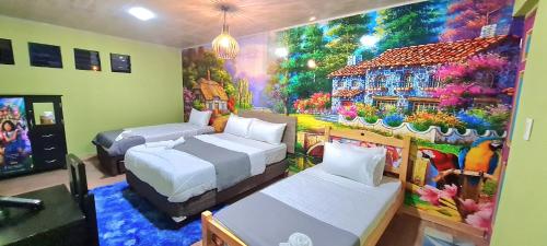 een kamer met twee bedden en een schilderij van een huis bij Hotel Restaurante La Bodega de Amar in Cajamarca