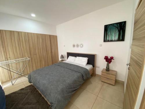 um quarto com uma cama e um vaso de flores em Luxurious 2 Bedroom space Available em Acra