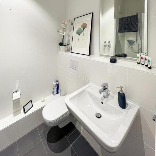 a white bathroom with a toilet and a sink at Holiday Home Munich in Munich