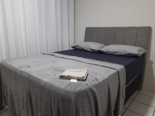 ein Bett mit einer Decke und einem Handtuch darauf in der Unterkunft APARTAMENTO EM CONDOMÍNIO FECHADO a 300 METROS DA FABRICA DE CHOCOLATE e a 600 METROS DO RELÓGIO DAS FLORES in Garanhuns