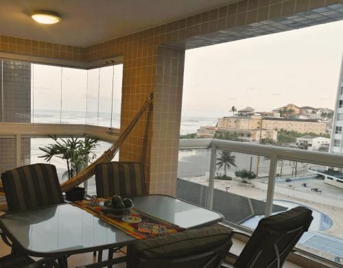 comedor con mesa y vistas al océano en Apartamento, ampla sacada com vista para o mar!, en Itanhaém