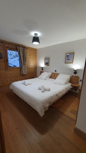 um quarto com uma cama grande com lençóis brancos e almofadas em Tignes2100 - Le Télémark em Tignes