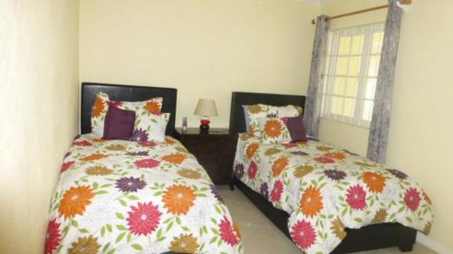 a bedroom with two beds and a window at Margate Gardens Opposite beautiful Beach, Bars, Restaurants, Boardwalk, Mall in Bridgetown