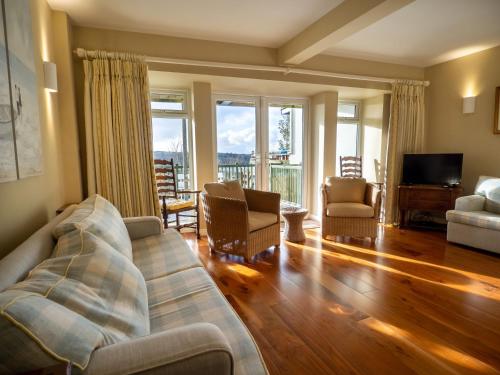 a living room with a couch and chairs and a television at Cottage 360 - Clifden in Clifden