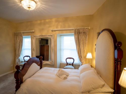 - une chambre avec un grand lit et des oreillers blancs dans l'établissement Cottage 360 - Clifden, à Clifden