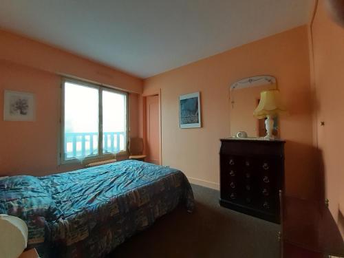 Schlafzimmer mit einem Bett, einem Spiegel und einem Fenster in der Unterkunft Appartement Trouville-sur-Mer, 3 pièces, 6 personnes - FR-1-712-68 in Trouville-sur-Mer