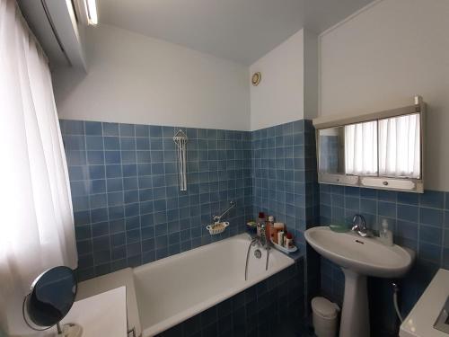 ein blau gefliestes Bad mit einem Waschbecken und einer Badewanne in der Unterkunft Appartement Trouville-sur-Mer, 3 pièces, 6 personnes - FR-1-712-68 in Trouville-sur-Mer