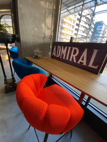 stół i dwa czerwone krzesła w restauracji w obiekcie Admiral Hotel w Mediolanie