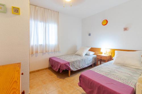 ein Zimmer mit zwei Betten und einem Fenster in der Unterkunft Flatguest Namibia SIN ASCENSOR in Mogán