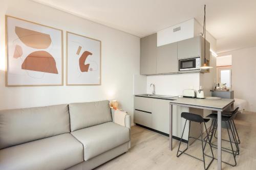 a living room with a couch and a kitchen at Bcn Town Apartments Born in Barcelona