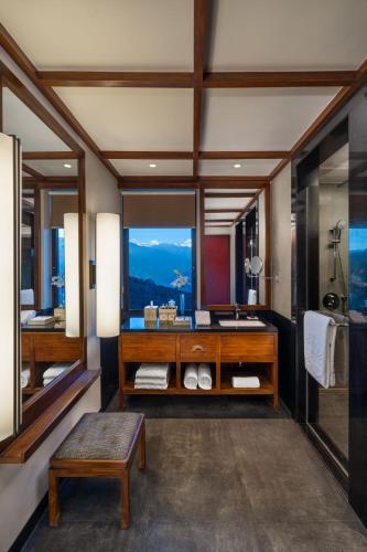 a bathroom with a shower and a sink and a table at Taj Guras Kutir Resort & Spa, Gangtok in Gangtok