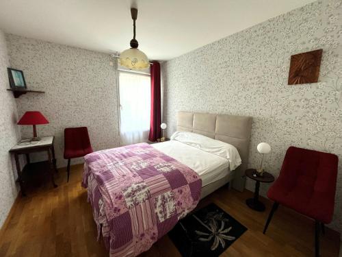 1 dormitorio con 1 cama y 2 sillas rojas en Appartement Les Sables-d'Olonne, 2 pièces, 2 personnes - FR-1-197-583, en Les Sables-dʼOlonne