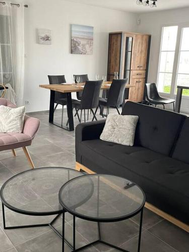 un salon avec un canapé, des tables et des chaises dans l'établissement Maison Moderne à Saint-Denis, à Saint-Denis-dʼOléron