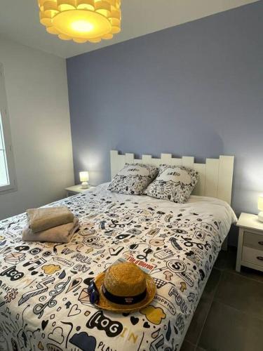 une chambre avec un lit avec un chapeau dessus dans l'établissement Maison Moderne à Saint-Denis, à Saint-Denis-dʼOléron