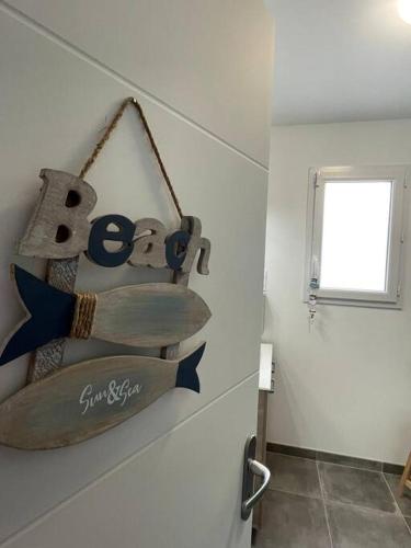 une planche de surf accrochée à un mur dans une pièce dans l'établissement Maison Moderne à Saint-Denis, à Saint-Denis-dʼOléron