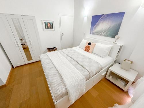 Habitación blanca con cama y espejo en Villa Olivo Maroni, en Maroni