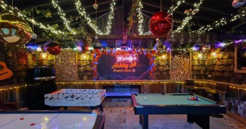 a bar with two pool tables and christmas lights at Beresford Cottage in Skegness