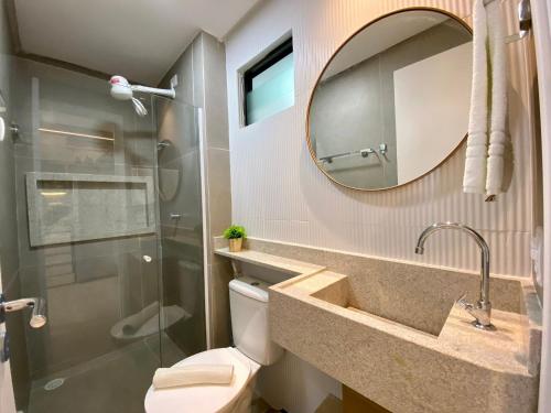 a bathroom with a toilet and a sink and a mirror at Green Porto 207 -Flat premium no centro de Porto in Ipojuca