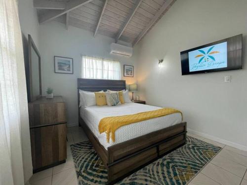 a bedroom with a bed and a tv on the wall at Unwind at Idyllic Escape! in Dickenson Bay