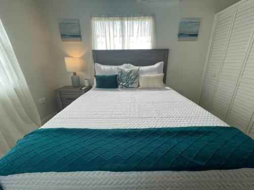 a bedroom with a large bed with blue and white sheets at Unwind at Idyllic Escape! in Dickenson Bay