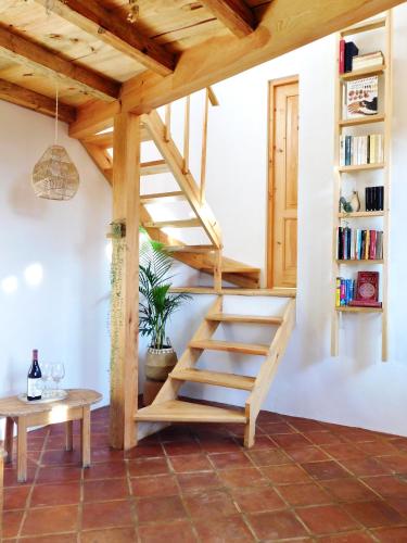 a wooden staircase in a room with a table at La Casa de las Aves - Architect's House/ Amazing view & garden in San Cristóbal de Las Casas