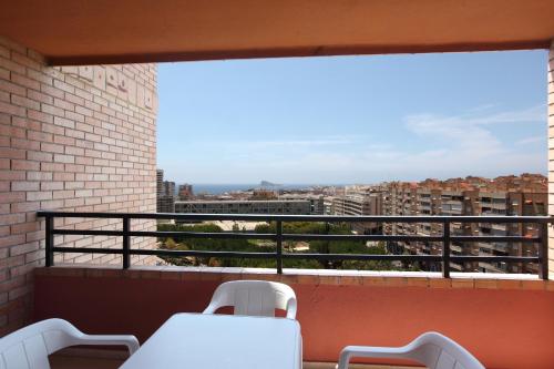 a balcony with chairs and a view of a city at Apartamentos La Caseta - SABESA in Benidorm