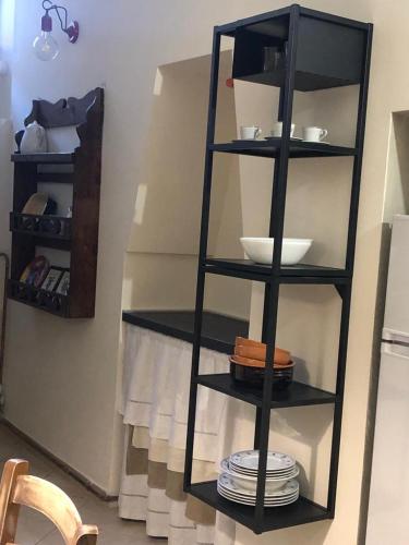 a black shelf with plates and bowls in a kitchen at Torri e Campanili in Ascoli Piceno