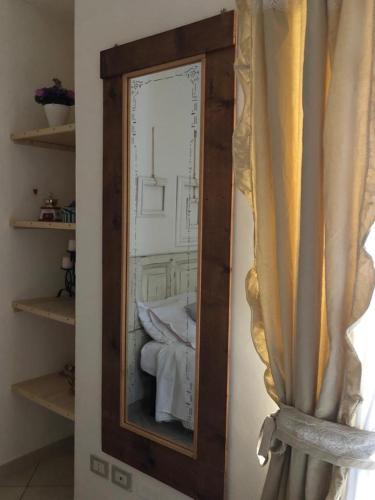 uno specchio con struttura in legno in una stanza di Torri e Campanili ad Ascoli Piceno